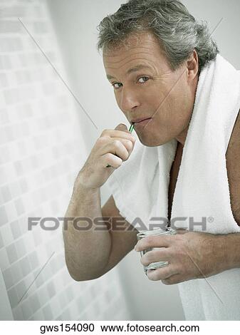 Portrait of a mature man brushing his teeth View Large Photo Image Stock Image - Portrait of a mature man brushing his teeth. Fotosearch