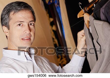 Portrait of a mature man holding a coat View Large Photo Image Stock Photograph - Portrait of a mature man holding a coat. Fotosearch