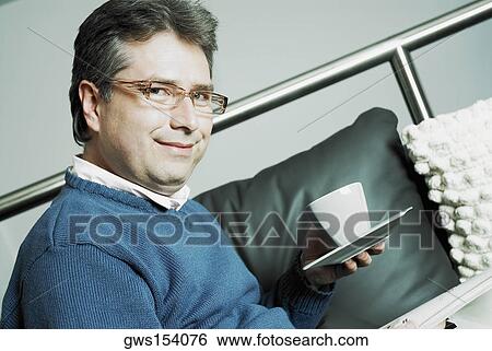 Portrait of a mature man holding a cup and saucer View Large Photo Image Stock Photograph - Portrait of a mature man holding a cup and saucer. Fotosearch