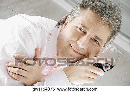 Portrait of a mature man holding a glass of red wine and smiling View Large Photo Image Stock Photography - Portrait of a mature man holding a glass of red wine and smiling. Fotosearch