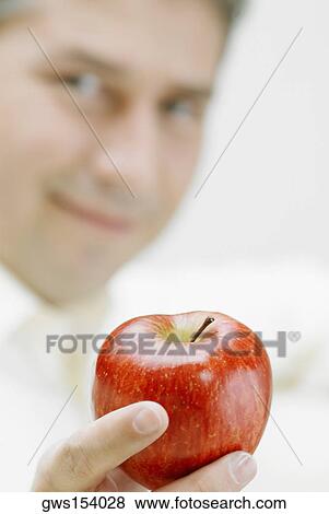 Portrait of a mature man holding an apple View Large Photo Image Stock Photo - Portrait of a mature man holding an apple. Fotosearch