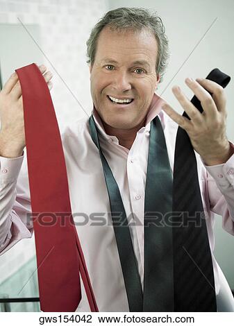 Portrait of a mature man holding ties and looking confused View Large Photo Image Stock Image - Portrait of a mature man holding ties and looking confused. Fotosearch