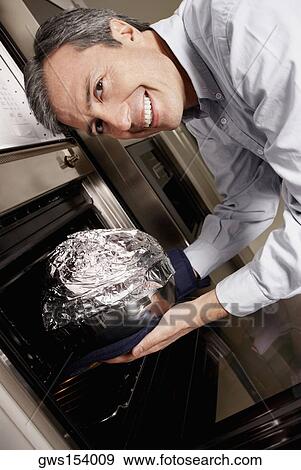 Portrait of a mature man inserting a dish wrapped in foil into a microwave and smiling View Large Photo Image Stock Photo - Portrait of a mature man inserting a dish wrapped in foil into a microwave and smiling. Fotosearch