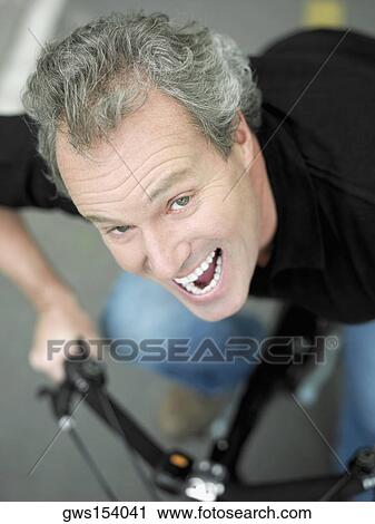 Portrait of a mature man sitting on a bicycle and laughing View Large Photo Image Stock Image - Portrait of a mature man sitting on a bicycle and laughing. Fotosearch