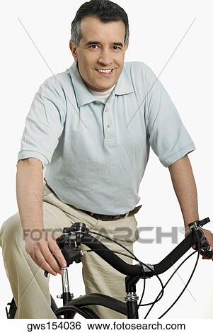 Portrait of a mature man sitting on a bicycle View Large Photo Image Stock Photograph - Portrait of a mature man sitting on a bicycle. Fotosearch