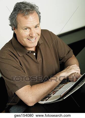 Portrait of a mature man smiling and holding a magazine View Large Photo Image Stock Image - Portrait of a mature man smiling and holding a magazine. Fotosearch