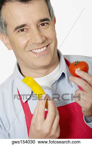 Portrait of a mid adult man holding a tomato View Large Photo Image Stock Image - Portrait of a mid adult man holding a tomato. Fotosearch