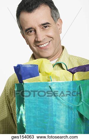 Portrait of a mid adult man holding a shopping bag View Large Photo Image Stock Image - Portrait of a mid adult man holding a shopping bag. Fotosearch