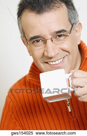 Portrait of a mid adult man holding a cup of coffee View Large Photo Image Stock Photography - Portrait of a mid adult man holding a cup of coffee. Fotosearch