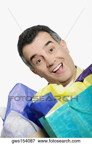 Portrait of a mid adult man holding shopping bags and laughing View Large Photo Image Stock Photo - Portrait of a mid adult man holding shopping bags and laughing. Fotosearch