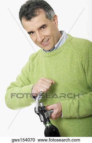 Portrait of a mid adult man opening the cork of a wine bottle View Large Photo Image Stock Image - Portrait of a mid adult man opening the cork of a wine bottle. Fotosearch