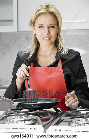 Portrait of a mid adult woman cooking food View Large Photo Image Stock Image - Portrait of a mid adult woman cooking food. Fotosearch