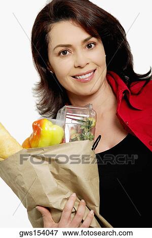 Portrait of a mid adult woman holding a shopping bag View Large Photo Image Stock Photo - Portrait of a mid adult woman holding a shopping bag. Fotosearch