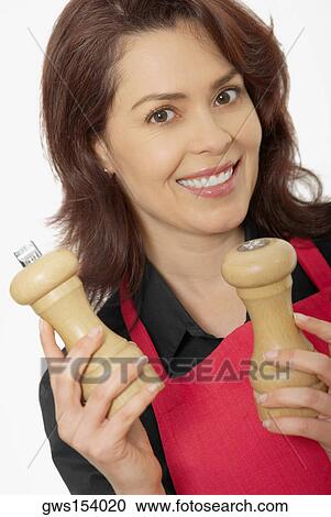 Portrait of a mid adult woman holding two pepper shakers View Large Photo Image Stock Image - Portrait of a mid adult woman holding two pepper shakers. Fotosearch