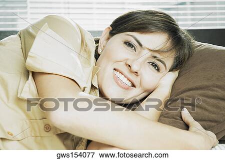 Stock Photo - Portrait of a mid adult woman lying on her side and smiling. Fotosearch