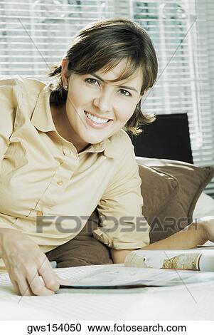 Portrait of a mid adult woman reclining on the bed and smiling View Large Photo Image Stock Image - Portrait of a mid adult woman reclining on the bed and smiling. Fotosearch