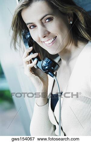 Portrait of a mid adult woman talking on a pay phone View Large Photo Image Stock Photo - Portrait of a mid adult woman talking on a pay phone. Fotosearch