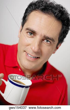 Portrait of a young man holding a tea cup View Large Photo Image Stock Photo - Portrait of a young man holding a tea cup. Fotosearch