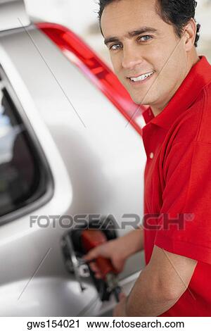 Portrait of a young man refueling a car View Large Photo Image Stock Image - Portrait of a young man refueling a car. Fotosearch