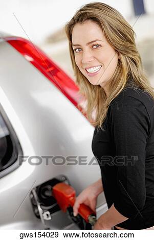 Portrait of a young woman refueling a car View Large Photo Image Stock Photo - Portrait of a young woman refueling a car. Fotosearch