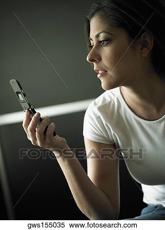 Close-up of a mid adult woman holding a mobile phone View Large Photo Image Stock Photography - Close-up of a mid adult woman holding a mobile phone. Fotosearch