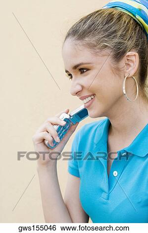 Stock Photograph - Close-up of a teenage girl holding a mobile phone and smiling. Fotosearch