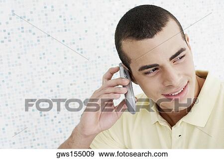 Close-up of a young man talking on a mobile phone View Large Photo Image Stock Photo - Close-up of a young man talking on a mobile phone. Fotosearch