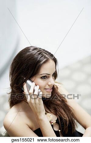 Close-up of a young woman talking on a mobile phone View Large Photo Image Stock Image - Close-up of a young woman talking on a mobile phone. Fotosearch