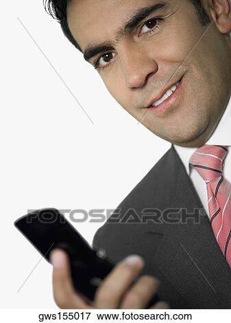 Portrait of a businessman holding a mobile phone and smiling View Large Photo Image Stock Photo - Portrait of a businessman holding a mobile phone and smiling. Fotosearch