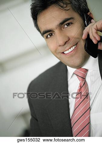 Portrait of a businessman talking on a mobile phone and smiling View Large Photo Image Stock Image - Portrait of a businessman talking on a mobile phone and smiling. Fotosearch