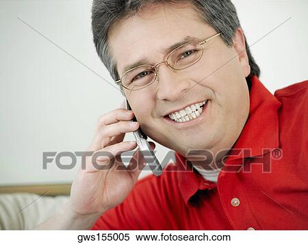 Portrait of a mature man talking on a mobile phone and smiling View Large Photo Image Stock Photography - Portrait of a mature man talking on a mobile phone and smiling. Fotosearch