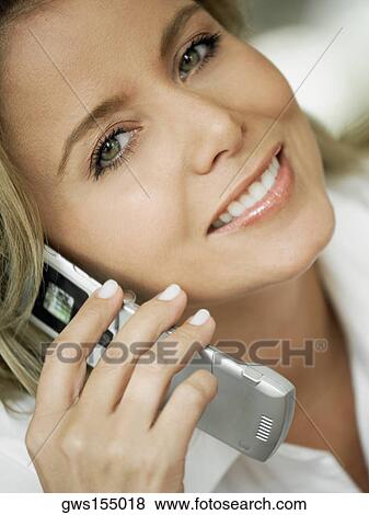 Portrait of a mid adult woman talking on a mobile phone and smiling View Large Photo Image Stock Photo - Portrait of a mid adult woman talking on a mobile phone and smiling. Fotosearch