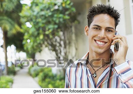 Portrait of a young man talking on a mobile phone View Large Photo Image Stock Image - Portrait of a young man talking on a mobile phone. Fotosearch