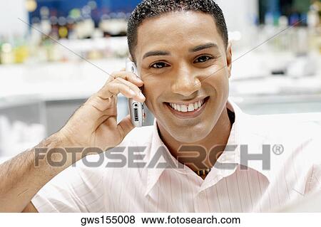 Portrait of a young man talking on a mobile phone View Large Photo Image Stock Photo - Portrait of a young man talking on a mobile phone. Fotosearch