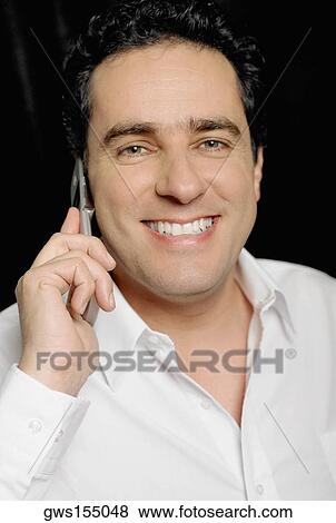 Portrait of a young man talking on a mobile phone and smiling View Large Photo Image Stock Photo - Portrait of a young man talking on a mobile phone and smiling. Fotosearch