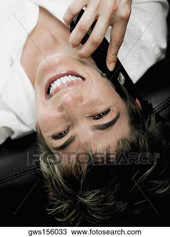 Close-up of a mature woman lying on her back and talking on a mobile phone View Large Photo Image Stock Image - Close-up of a mature woman lying on her back and talking on a mobile phone. Fotosearch