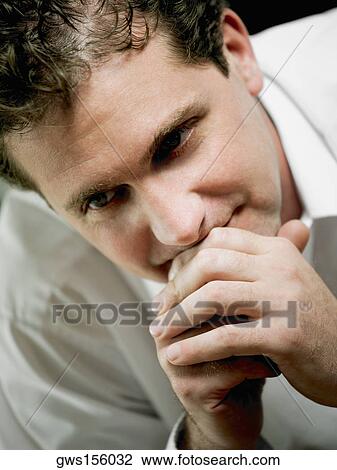Stock Image - Close-up of a mid adult man thinking. Fotosearch
