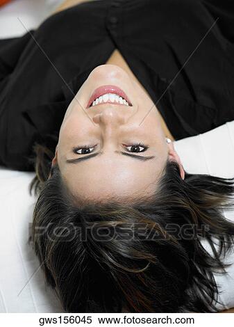 Stock Photography - Portrait of a businesswoman lying on the bed and smiling. Fotosearch