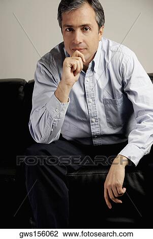 Portrait of a mature man sitting on a couch and thinking View Large Photo Image Stock Image - Portrait of a mature man sitting on a couch and thinking. Fotosearch