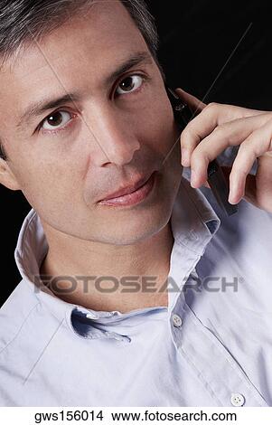 Picture - Portrait of a mature man talking on a mobile phone. Fotosearch