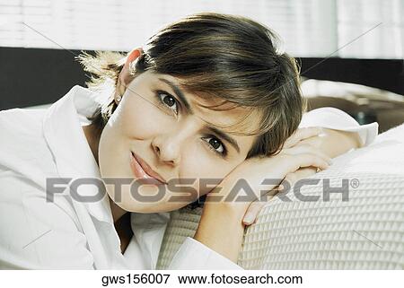 Portrait of a mid adult woman leaning against a bed View Large Photo Image Stock Photo - Portrait of a mid adult woman leaning against a bed. Fotosearch