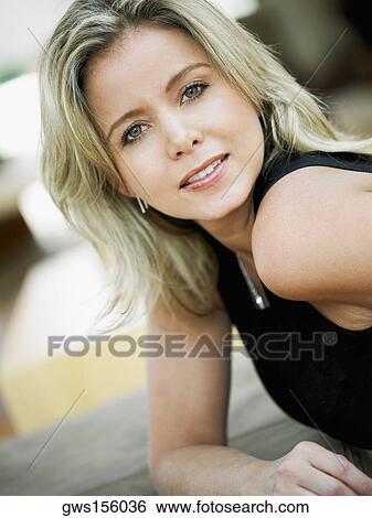 Portrait of a mid adult woman leaning on a couch View Large Photo Image Stock Photograph - Portrait of a mid adult woman leaning on a couch. Fotosearch