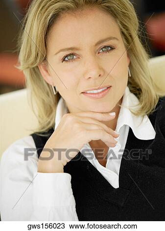 Portrait of a mid adult woman with her hand on her chin View Large Photo Image Stock Image - Portrait of a mid adult woman with her hand on her chin. Fotosearch