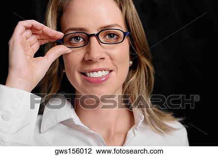 Portrait of a young woman adjusting her eyeglasses View Large Photo Image Stock Image - Portrait of a young woman adjusting her eyeglasses. Fotosearch
