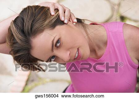 Portrait of a young woman stretching her neck View Large Photo Image Picture - Portrait of a young woman stretching her neck. Fotosearch