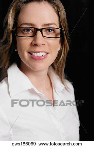 Portrait of a young woman wearing eyeglasses and smiling View Large Photo Image Stock Photo - Portrait of a young woman wearing eyeglasses and smiling. Fotosearch