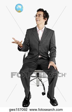 Businessman throwing a globe View Large Photo Image Stock Image - Businessman throwing a globe. Fotosearch