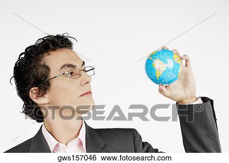 Stock Photograph - Close-up of a businessman holding a globe. Fotosearch