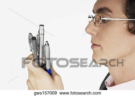 Stock Photo - Close-up of a businessman holding pens. Fotosearch