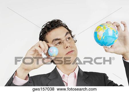 Close-up of a businessman holding two globes View Large Photo Image Stock Photo - Close-up of a businessman holding two globes. Fotosearch